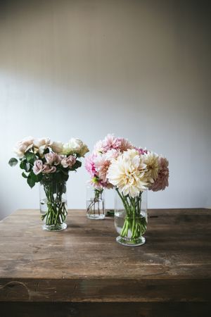 Bunches of flowers in vases on table