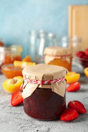Composition with jam and ingredients on gray table, space for text