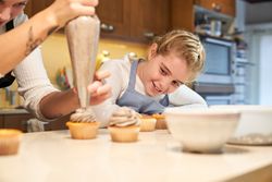 Happy girl making homemade pastry together with mom