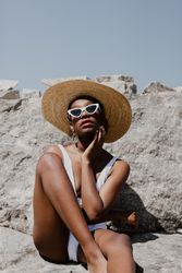 Woman in swimsuit wearing sunglasses and sun hat
