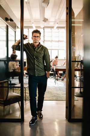 Young man standing in doorway at startup office