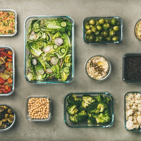 Variety of vegetable dishes arranged in glass containers, square crop