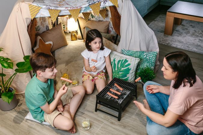 Top view of family grilling and eating sausages on barbecue