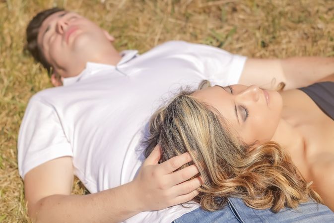 Love couple lying on the grass in a summer day