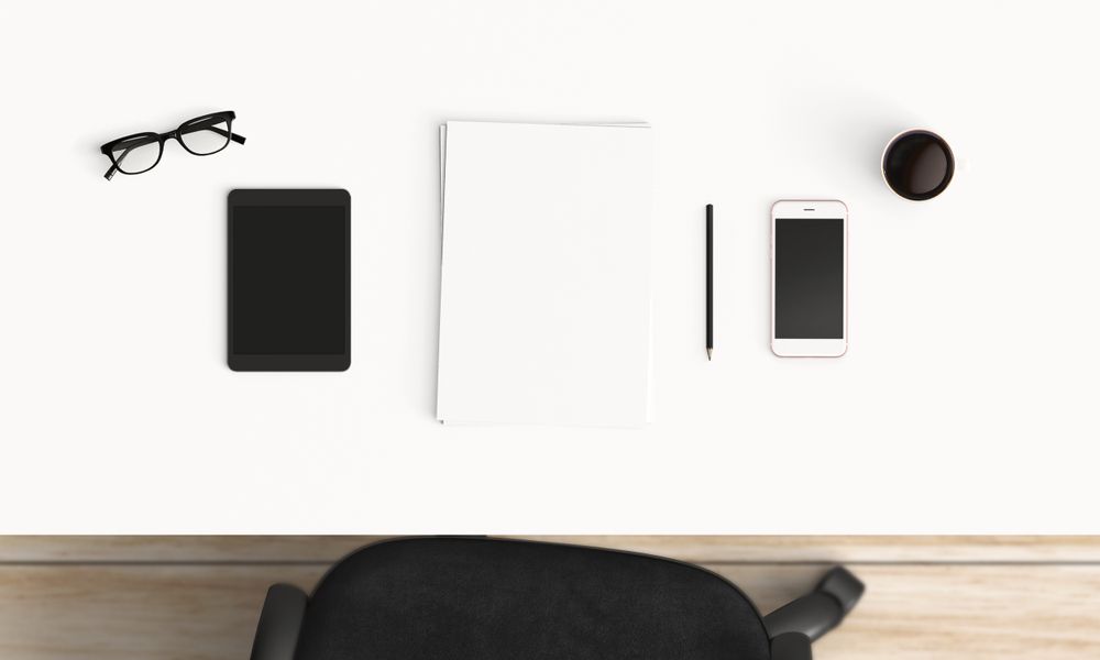 Modern workplace with coffee cup and smartphone or laptop copy space on office table background. Top view. Flat lay style