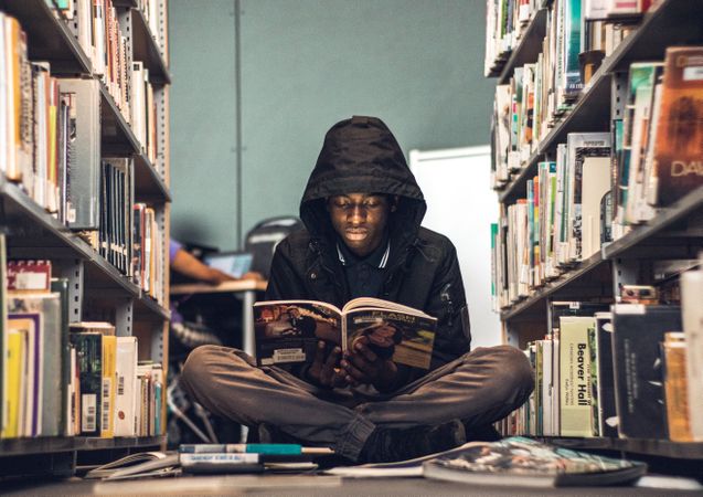 Man reading a book in university library