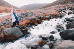 Woman on stones near mountain river