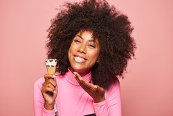 Funny woman with ice cream on stick looking at camera