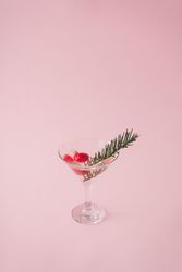 Christmas tree decoration in martini glass on pastel pink background with creative copy space