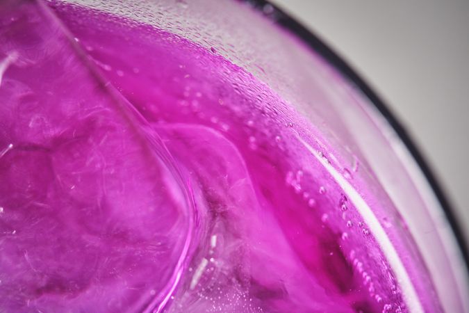Refreshing drink with purple ice with dehydrated orange slice