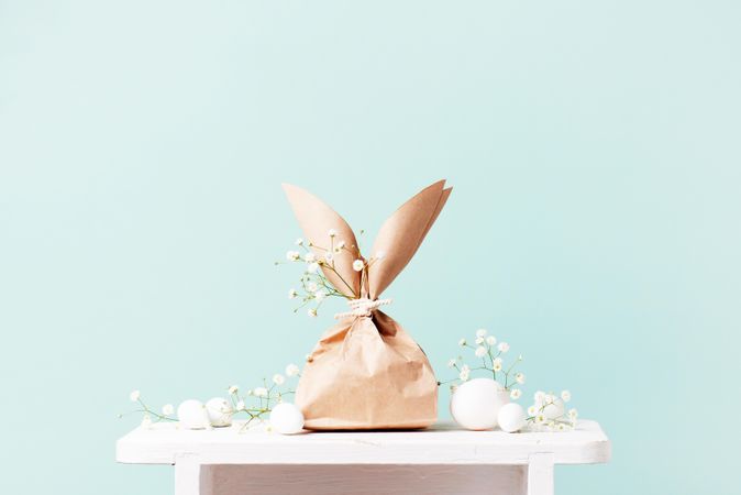 Two paper bags in Easter bunny shapes on table on blue background