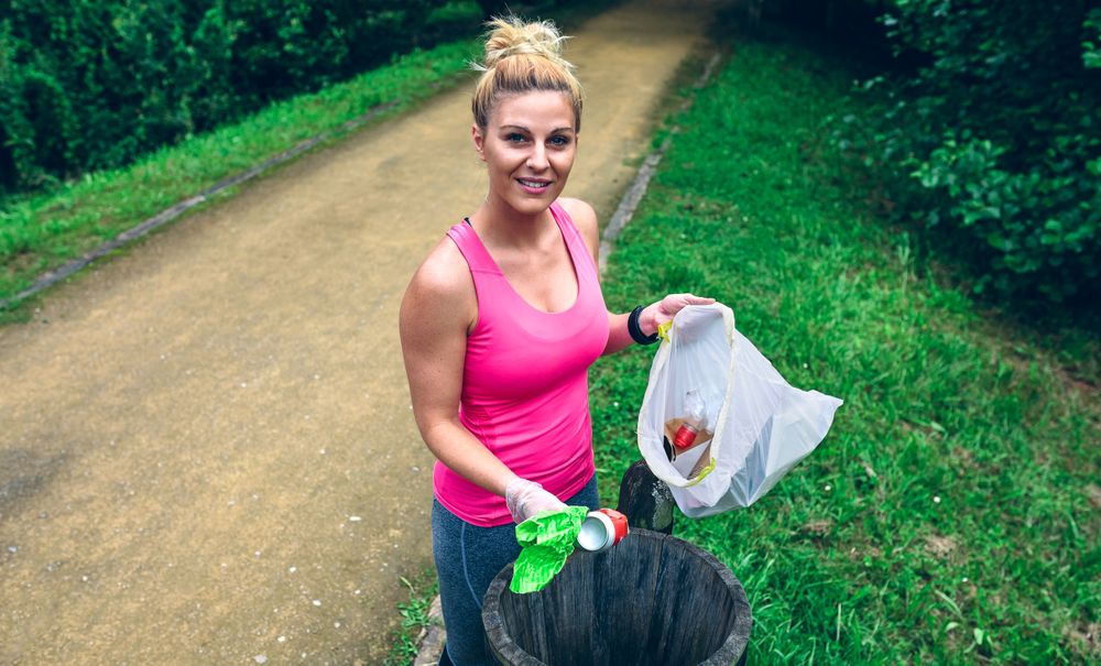 Woman throwing garbage after picking up litter in park