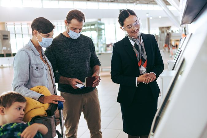 Ground staff giving help to traveler family at airport during pandemic