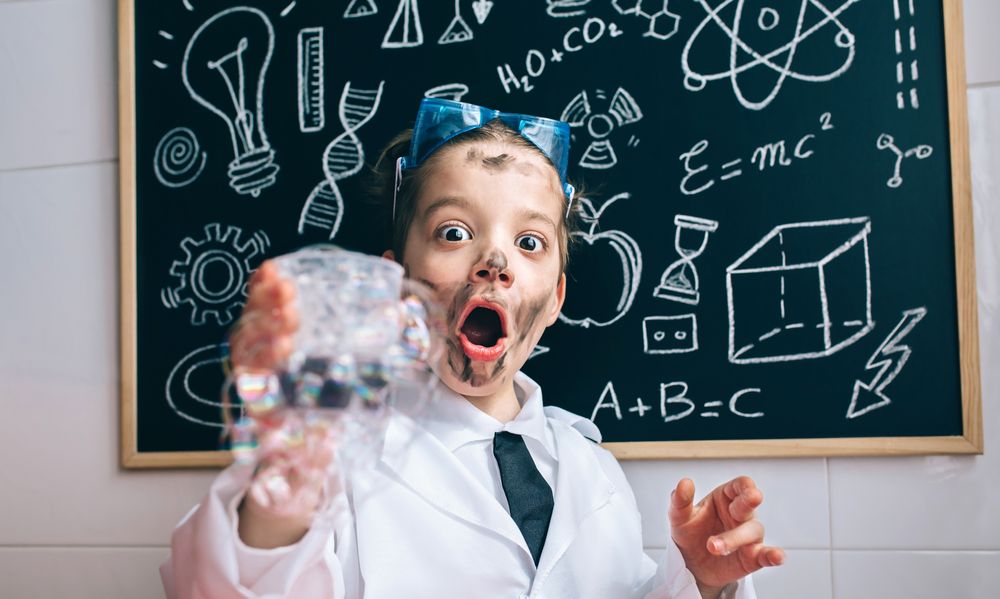 Happy little boy holding glass with soap foam