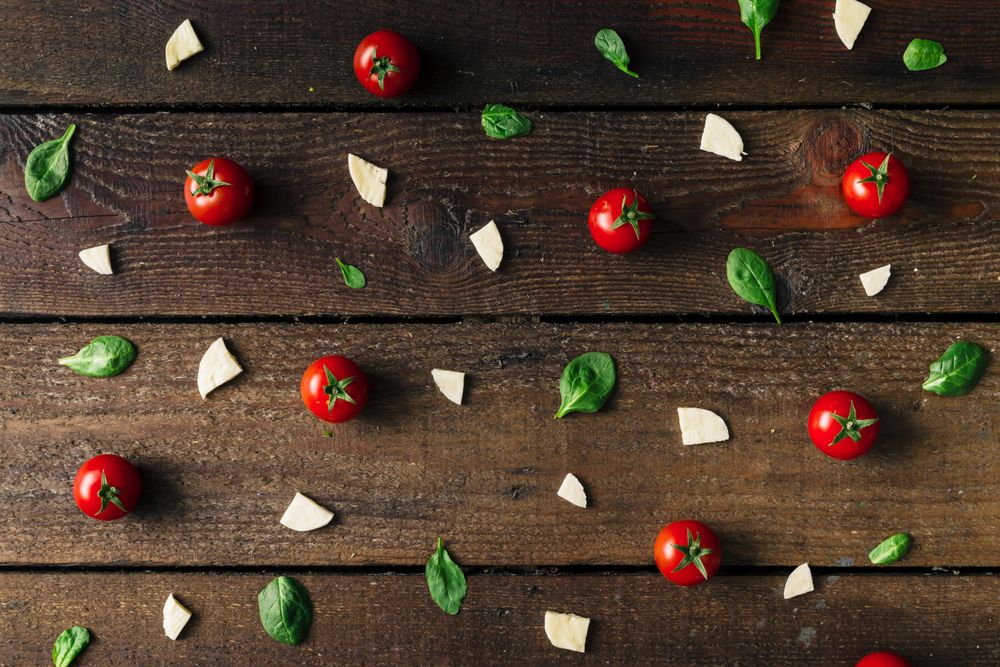 Basil, tomatoes, and cheese on wooden background