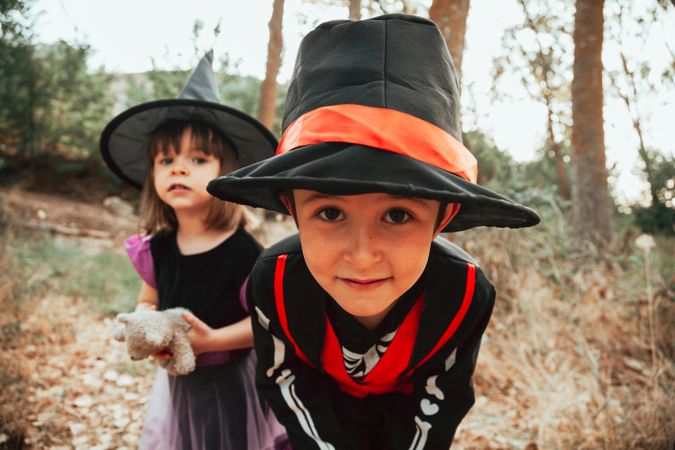 Brother and sister in skeleton and witch costumes