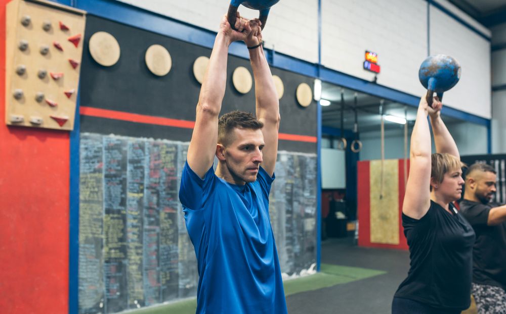 Sportsman exercising with kettlebell with his partners