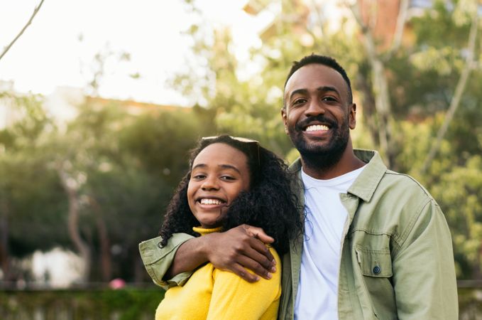 portrait of a Black man hugging his partner