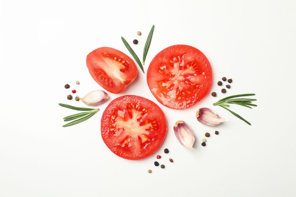 Tomatoes and ingredients on light background, top view