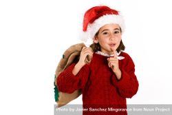 Child dressed as santa holding bag of presents 56pPYb