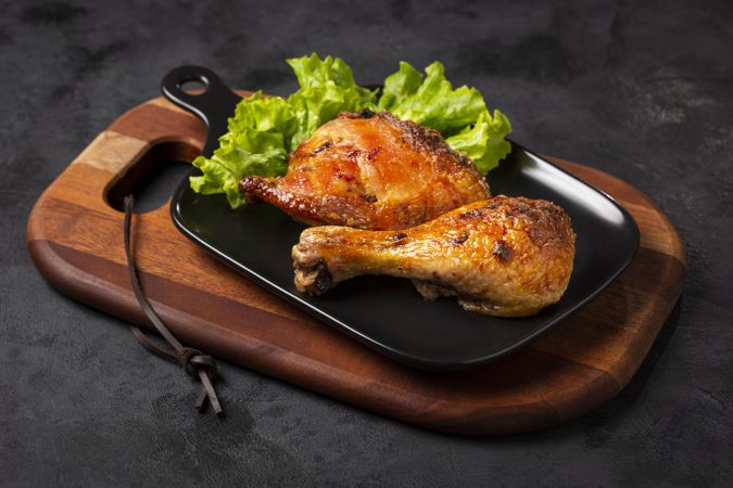 Roasted chicken pieces with lettuce salad.