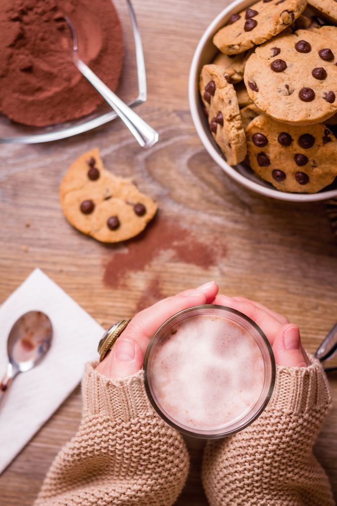 Female hands with hot drink and chocolate cookies