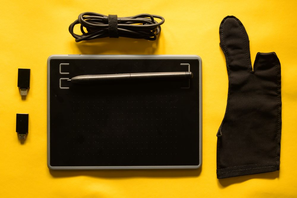 Digital tablet and accessories for graphic designer on yellow table