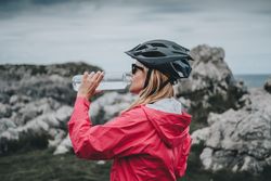 Female drinking water on mountains background