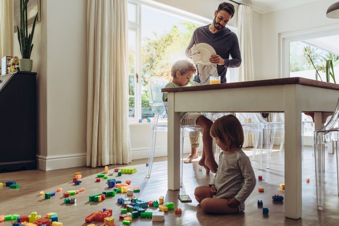 Man looking after his kids while doing the household works
