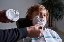 Boy shaving in a barbershop