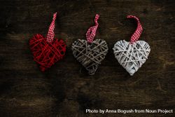 Valentine's day concept of three thatched heart decorations on wooden table 4ZeeP3