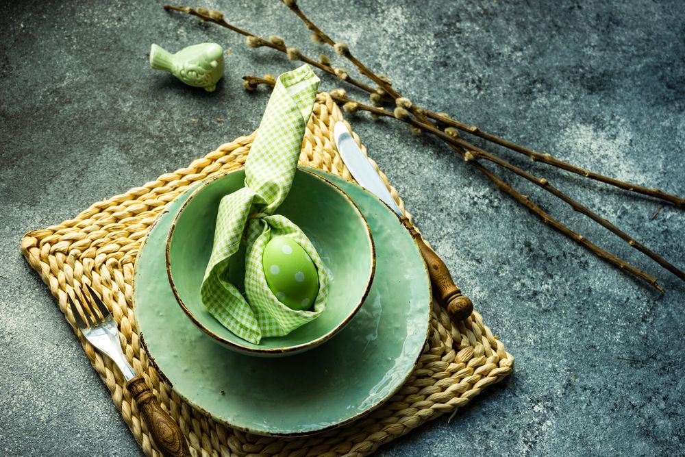 Easter holiday table setting with pastel egg wrapped in rabbit napkin