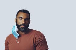 Male with medical face mask off looking at camera in studio shoot