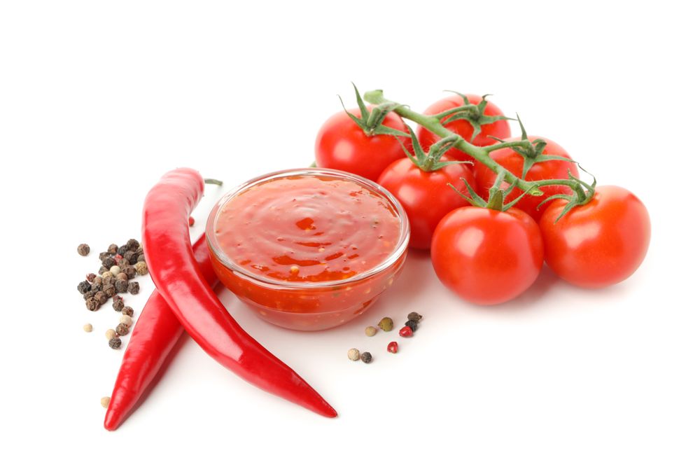 Branch of tomatoes, pepper and sauce isolated on plain background