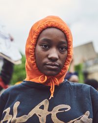 London, England, United Kingdom - June 6th, 2020: Young man in orange hooded sweatshirt