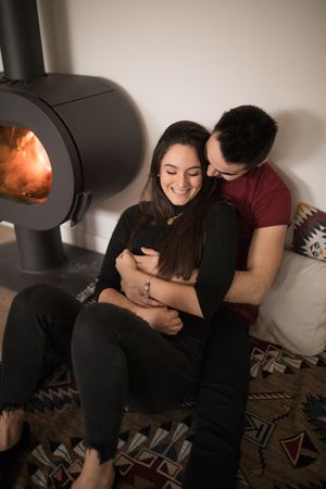 Couple sitting near fireplace on floor