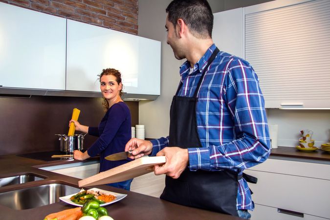 Couple in kitchen together preparing pasta for dinner