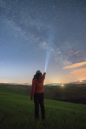 Traveler lighting with torch in starry sky