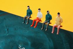 Four toy figures sitting on edge of pool