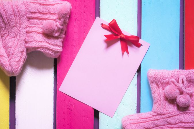 Cute message card and pink baby booties with copy space