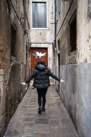 Anonymous woman strolling on rocked alley