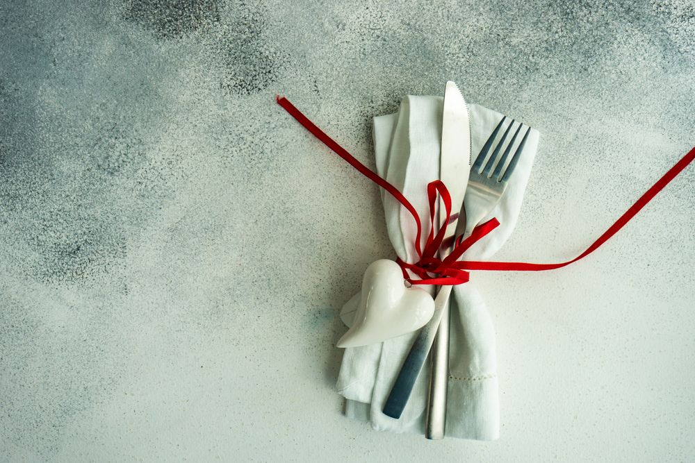 St. Valentine's Day card with cutlery wrapped with ribbon and heart ornaments