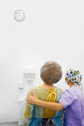 Rear view of patient just out of surgery with doctor, vertical
