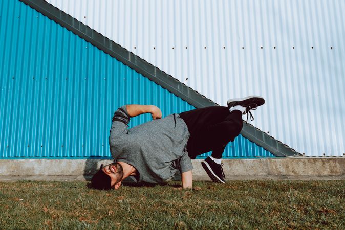 Man performing handstand near wall