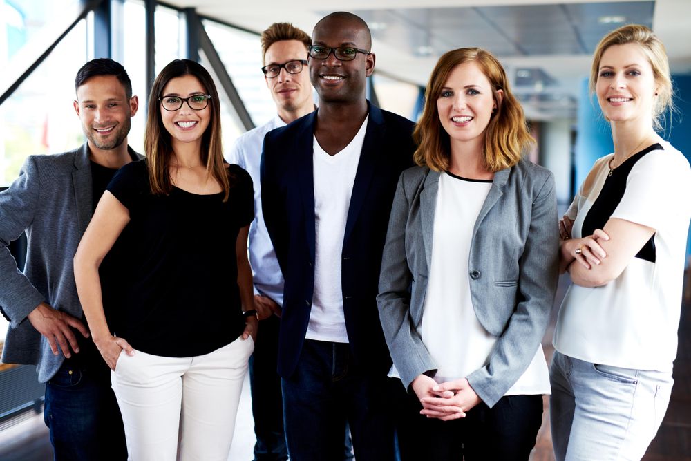 Business associated standing in a row in a bright office