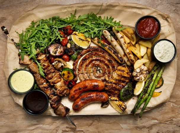 Sauces near fried meat and vegetables