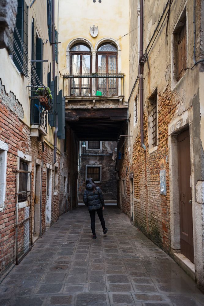 Anonymous woman strolling on rocked alley