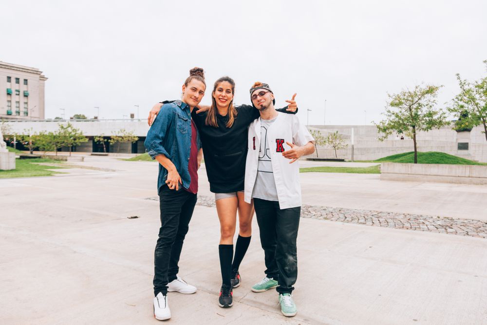 Cheerful friends in embrace at city street