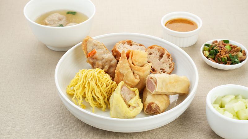 Bakso Malang, meatball soup with tofu, fried shumay, noodles and dumplings. Served with sambal and cucumber