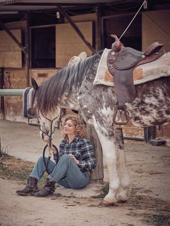 Woman with horse in paddock